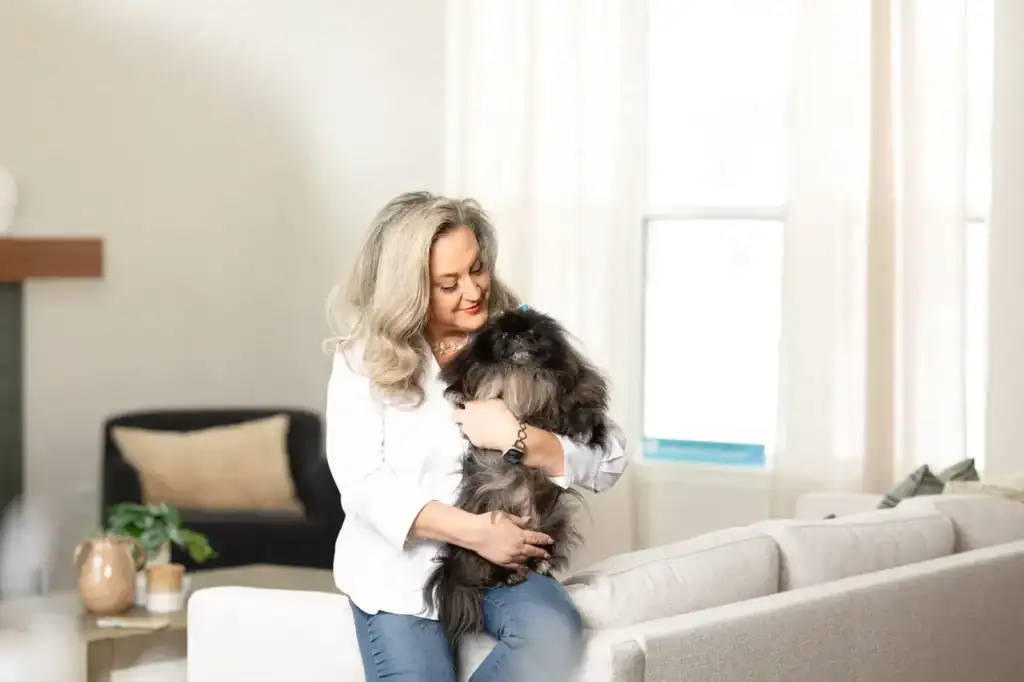 Woman with a dog in a bright, modern living room.